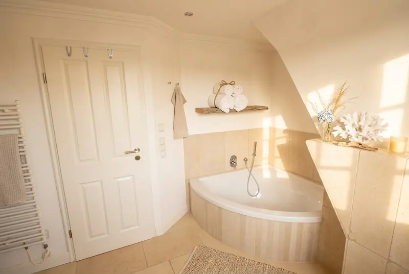 Badezimmer mit Limestone-Natursteinfliesen und freistehender Wanne