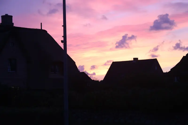Reetdachhäuser im rosa Abendhimmel