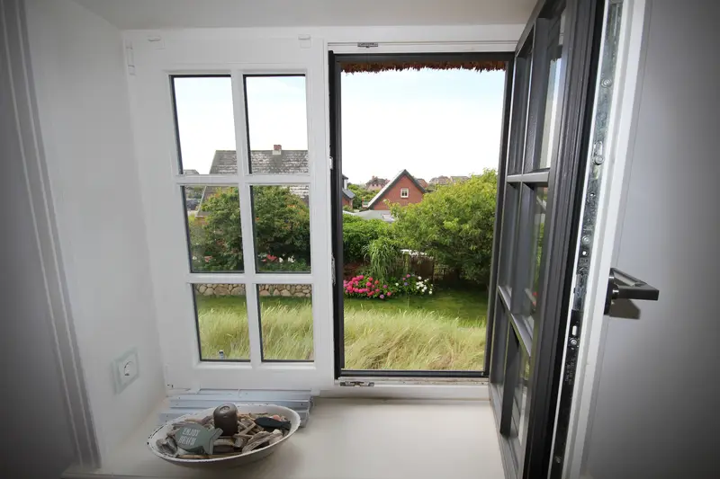 Blick aus dem geöffneten Sprossenfenster in den Dünengarten